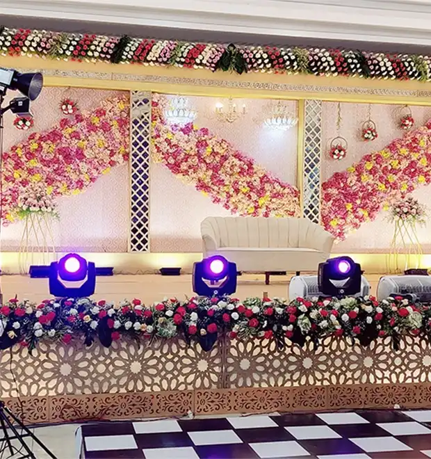 Bride and groom seated on a decorated wedding stage during a celebration event in Erode