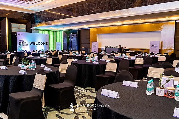 Premium indoor corporate conference venue packed with international delegates and large LED walls.