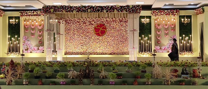Indoor wedding venue with elegant stage decoration, seating and event arrangements in Erode