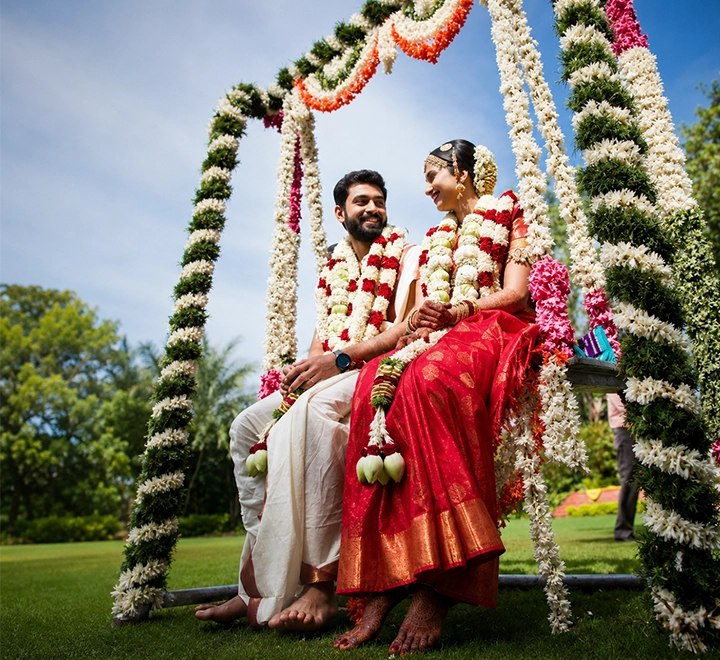 Elegantly decorated Oonjal swing with flowers and traditional décor for Brahmin wedding ceremonies.
