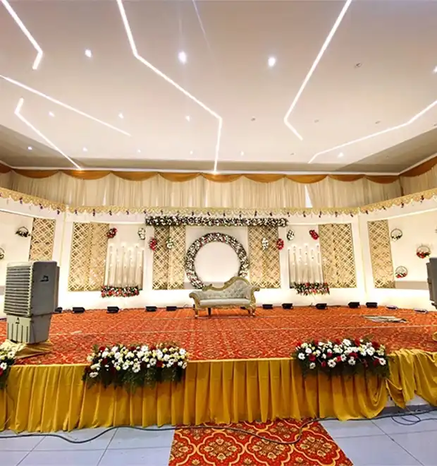 Wedding celebration stage decorated with floral arrangements and elegant lighting for guests in Erode